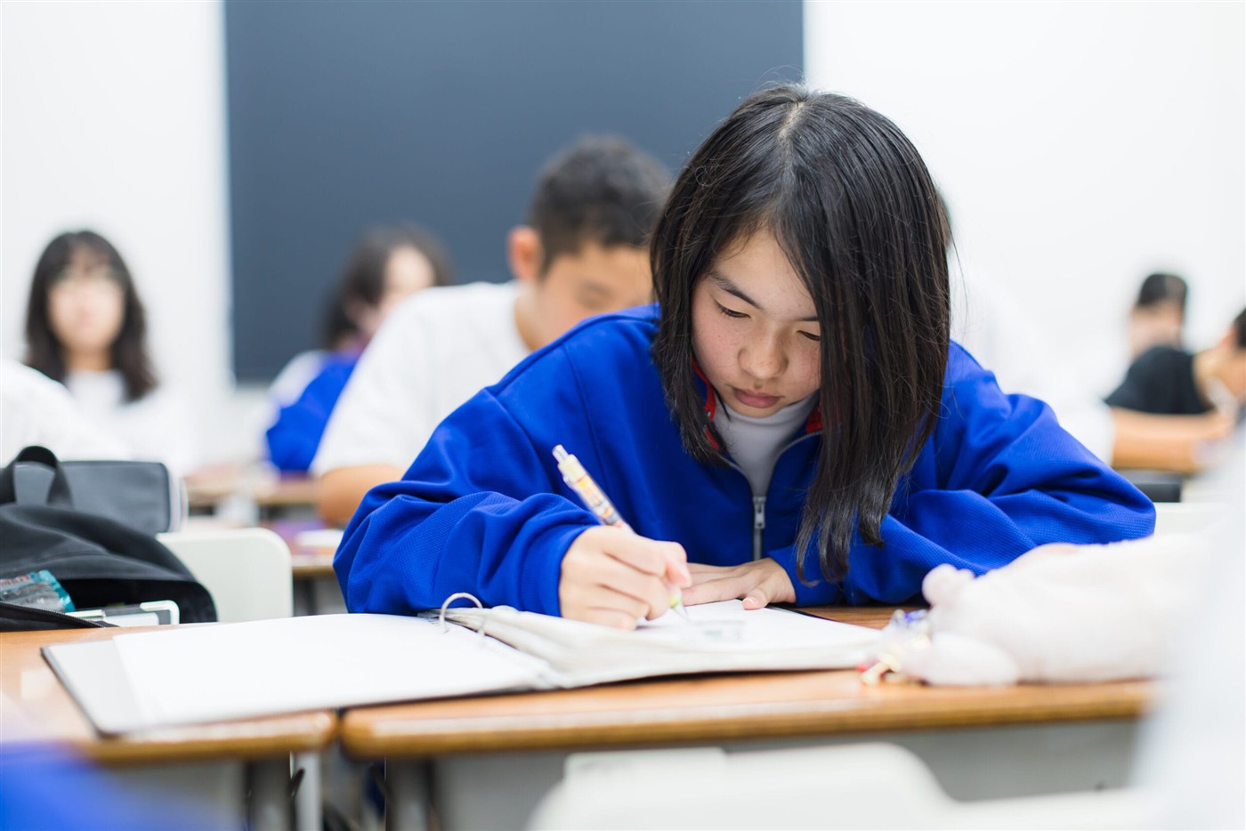 授業中に集中してノートをとる中学生
